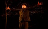 A young man turning his back to the woods in "The Village"